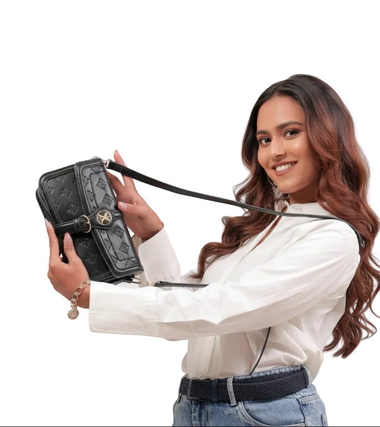 KARRYOL black embossed monogram crossbody bag with gold-tone hardware and adjustable strap, held by a smiling woman.
