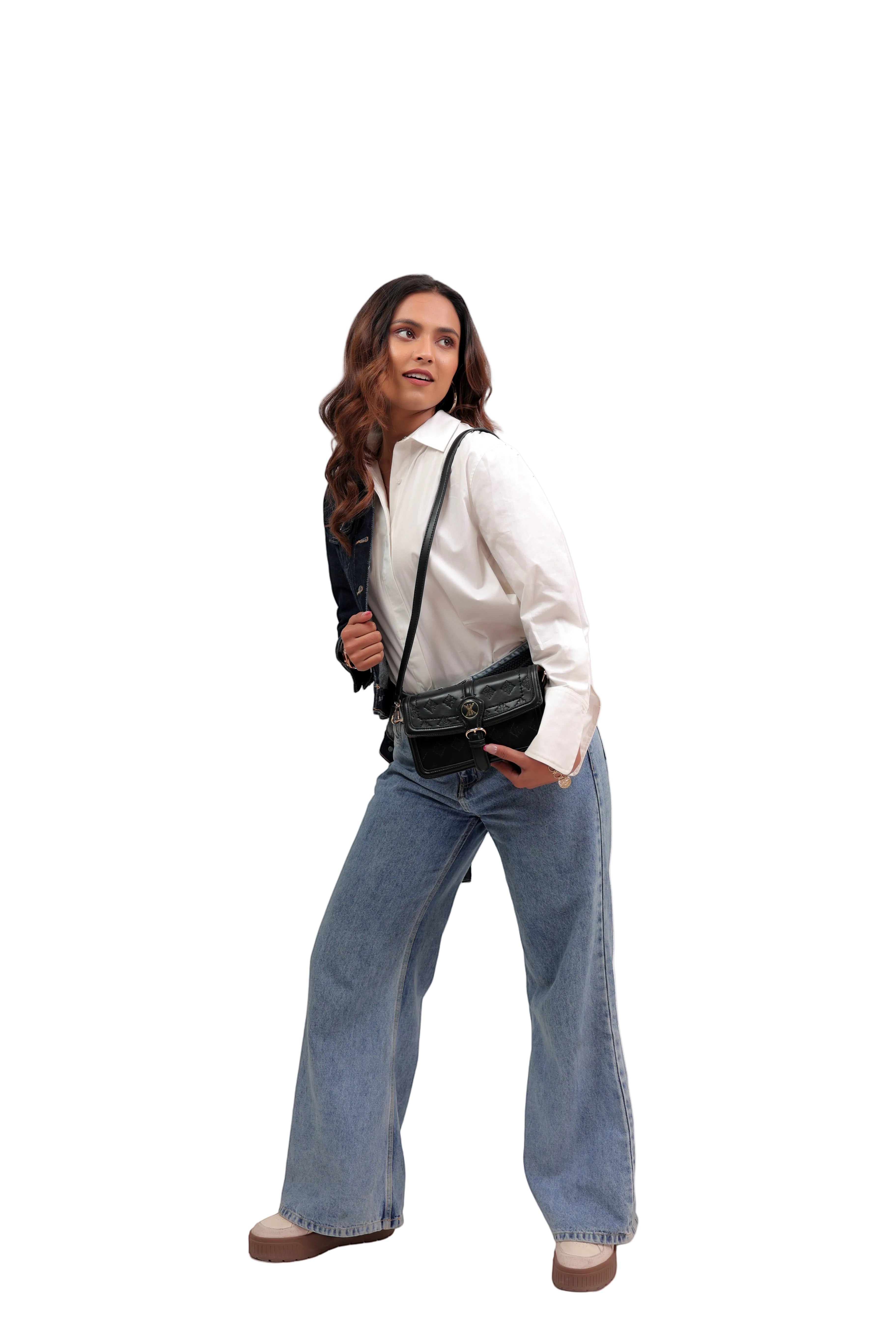KARRYOL black leather Kari crossbody bag with embossed monogram panel and gold-tone hardware, worn by a woman in a white shirt and jeans.