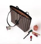 KARRYOL Simmone black monogram canvas tote bag with contrast leather trim and dual top handles. Includes interior pockets and zip closure.