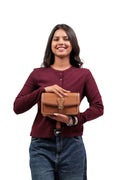 KARRYOL tan leather crossbody bag with embossed monogram panel and gold-tone buckle detail.