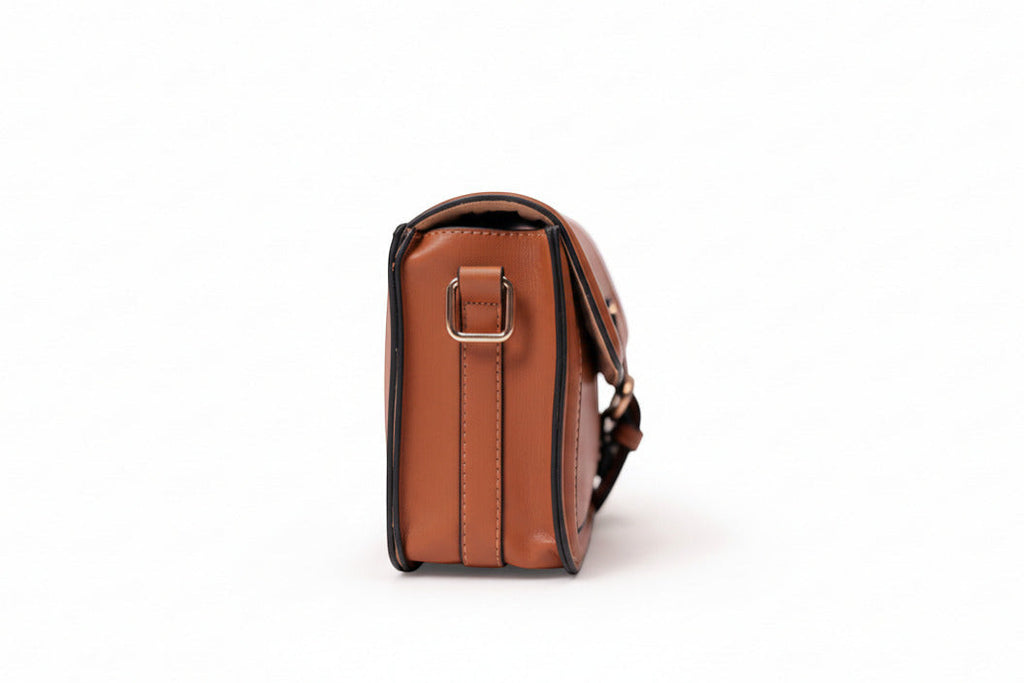 KARRYOL tan leather Kari crossbody bag with gold-tone hardware and embossed monogram panel.