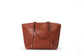KARRYOL tan leather Monica tote bag with dual top handles, zipper closure, and embossed logo.