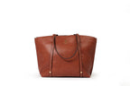 KARRYOL tan leather Monica tote bag with dual top handles, zipper closure, and embossed logo.