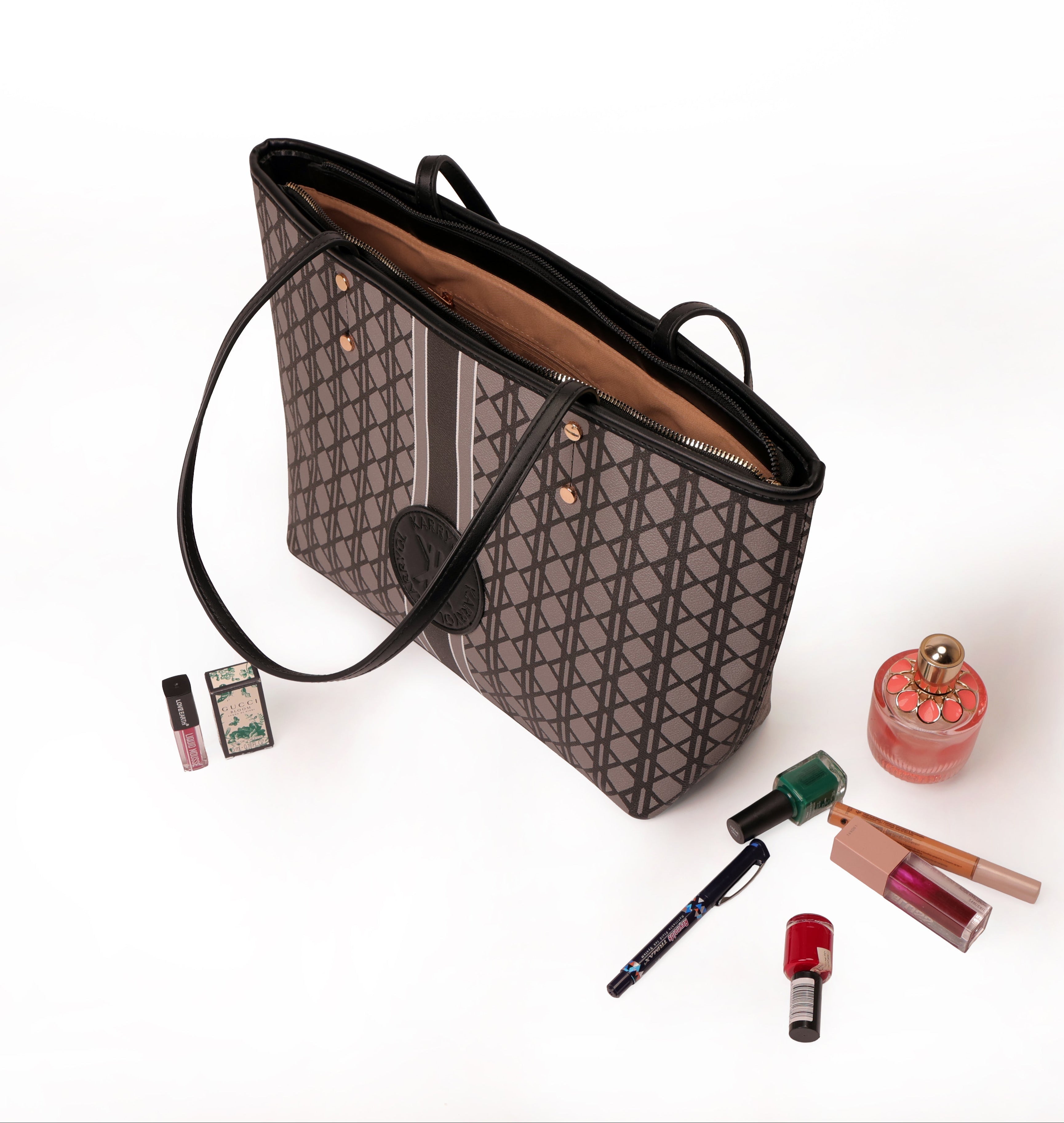 Black handbag with makeup items on a white background